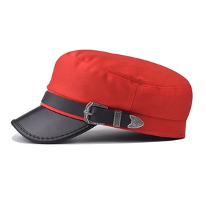 Detail of red canvas military hat featuring a black leather brim and silver metal buckle
