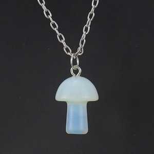 Close-up of a translucent opalite mushroom pendant on a silver metal chain necklace