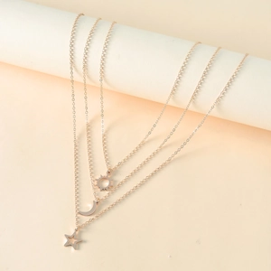 Détail du collier doré multicouche avec pendentifs soleil, croissant de lune et étoile