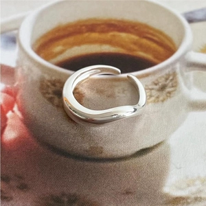 Macro detail of minimalist S925 sterling silver wavy open ring with polished finish