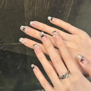 Handmade ballet cat eye press-on nails with 3D bows and pearls on a dark wood background