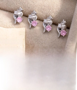 Macro detail of heart stud earrings with pink zirconia and medical grade titanium posts