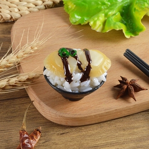 Macro shot of miniature seafood sushi bowl model with realistic abalone and sauce details