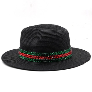 Close-up of black Panama straw hat with red and green rhinestone band detail