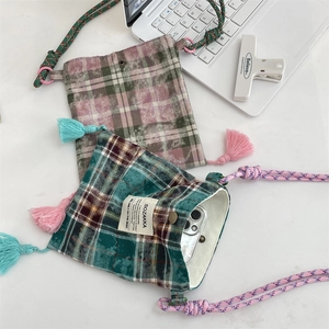 Close-up of retro plaid mini crossbody phone bags with fringe tassels and woven straps