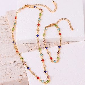 Close-up of gold-plated necklace and bracelet set featuring colorful zircon gemstones