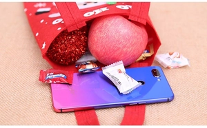 Detail view of red felt Christmas gift bag showing capacity with candy and phone
