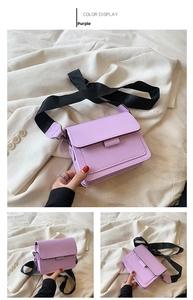 Detail of purple square crossbody bag showing stitching and wide black nylon shoulder strap