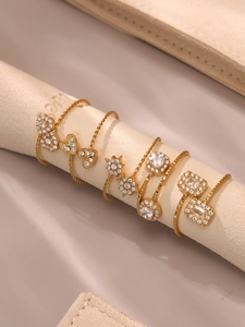 Gros plan d'un ensemble de bagues plaqué or 18k avec zircons 5A en forme d'étoile et cœur