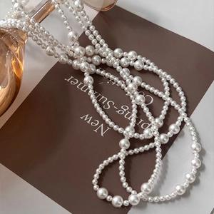 Artistic detail of elegant multi-strand pearl necklace on vintage paper background