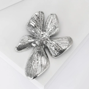 Detailed back view of silver clover brooch showing metal pin structure and leaf texture