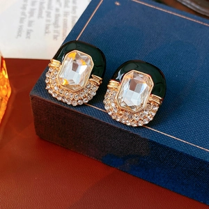 Macro view of vintage black enamel earrings with rectangular gem and crystal pavé details