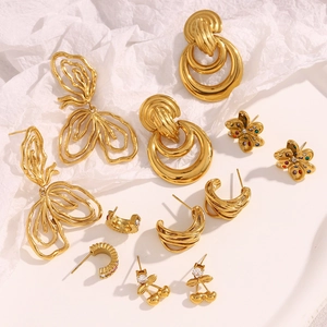 Detailed collection of 18K gold plated flower and cherry earrings on textured background