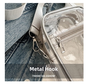 Close-up of durable metal hook and gray strap on a transparent waterproof crossbody bag