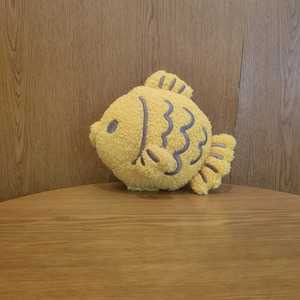Detail of yellow taiyaki plush toy showing soft sherpa fabric and stitched fin texture