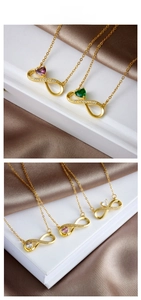 Close-up of gold infinity heart necklace with colorful gems on silk and book