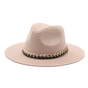 Detail of Panama hat with golden metal chain and black leather band on straw texture