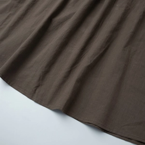 Vue détaillée macro de l'ourlet à double couture d'une robe en coton marron