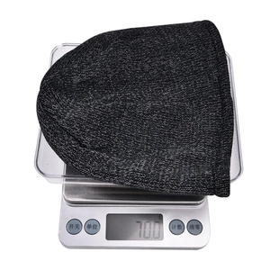 Detail showing the 70.0g lightweight reflective knit beanie on a digital scale