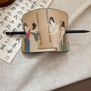 Nahaufnahme der Leder-Haarnadel mit Tang-Gemälde auf rustikalem Leinenhintergrund