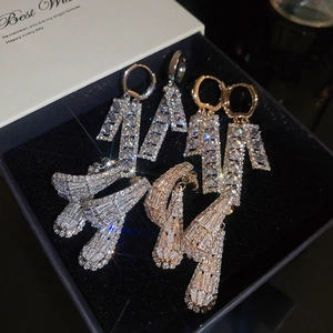 Detail of luxury gold and silver earrings with zircon tassels in a gift box