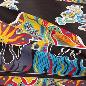 Close-up of bohemian tapestry fabric showing dragonfly and sun surreal patterns