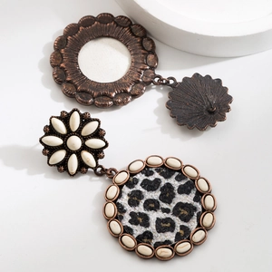 Detail of bohemian drop earrings with leopard print and sunburst stud design