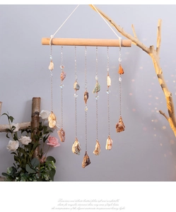 Macro detail of natural raw crystals wire-wrapped on metal chains with wooden bar hanging