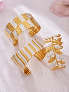 Details der Blattmuster und emaillierten breiten Armreifen in Gold und Weiß-Finish