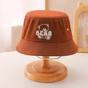 Detail view of caramel cotton canvas bucket hat with bear embroidery and windproof strap