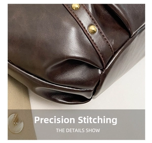 Close-up of precise stitching and gold rivet details on brown wax leather handbag