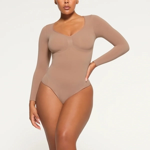 Macro shot of V-neck nude knit bodysuit showing stretch fabric texture and fit