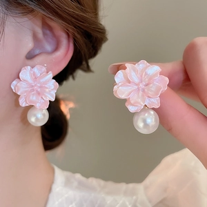 Detail of pink resin flower earring with white pearl drop on model and in hand