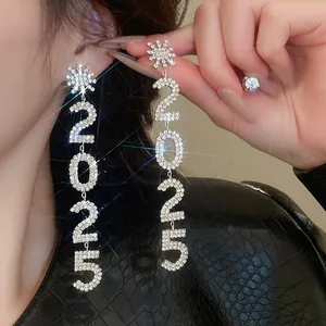 Gros plan sur les boucles d'oreilles pendantes 2025 avec flocons de neige et strass brillants