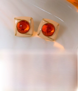 Detail view of vintage orange resin stud earrings with vacuum-plated copper finish