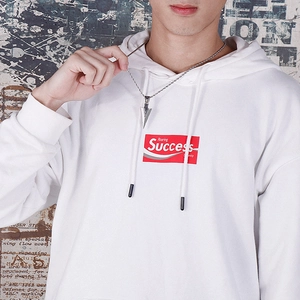 Close-up of silver arrowhead pendant on rope chain worn with a white streetwear hoodie