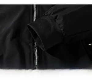 Detail of ribbed elastic cuffs and metal zipper closure on black casual jacket