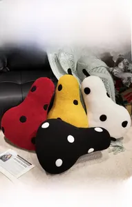 Polka dot pear plush pillows in vibrant colors styled on a sofa in a cozy home setting