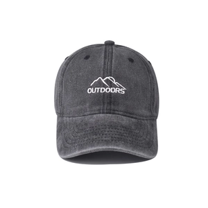 Detail shot of mountain embroidery and washed cotton texture on a charcoal baseball cap
