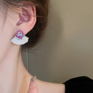 Detail showing vintage purple crystal fan-shaped earring with shimmering diamond accents