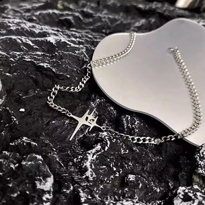 Silver star pendant titanium steel necklace with Cuban chain on stone background