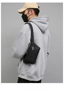 Side view of a black durable nylon waist bag with double zippers worn by a model