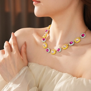 Detail of vintage necklace with pink and purple gems and colorful enamel borders