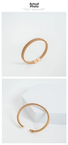 Dettaglio di bracciali in acciaio inossidabile dorato con trama a maglia intrecciata