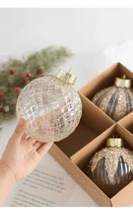 Detail of transparent Christmas ball with gold glitter lattice pattern and hanging cap