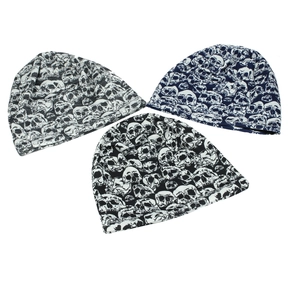 Detailed overhead view of knit beanies with skull patterns in black, grey, and navy colors