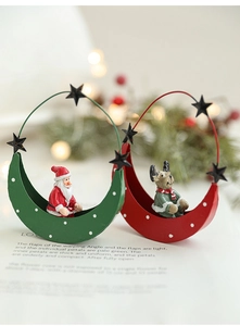 Close-up of crescent moon Christmas ornaments with Santa and reindeer on a magazine