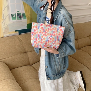 Floral cotton cosmetic bag featuring vibrant tulip prints held by a model in a cozy room