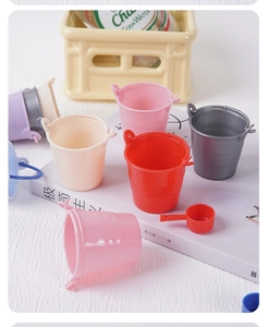 Detalle macro de mini cubos de plástico coloridos y cucharón para escenas de casas de muñecas