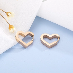 Close-up of rose gold heart-shaped hoop earrings on a clean decorative background